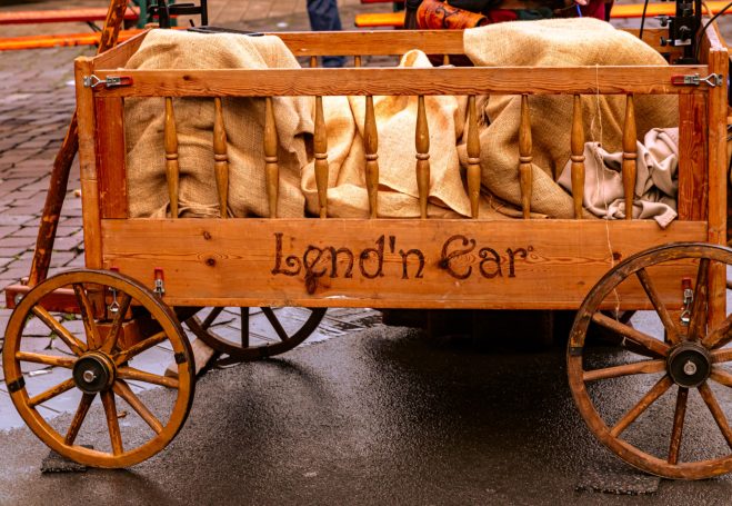 Holzkarren mit der Aufschrift "Lend'n Ear", gefüllt mit weichen, beige Tüchern.