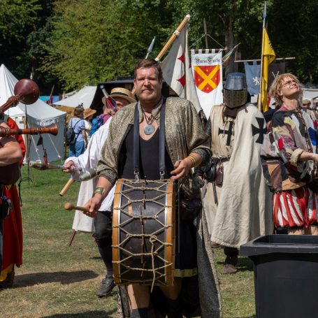 Ein mittelalterlicher Markt mit Darstellern in Kostümen und einem Trommler in der Mitte.