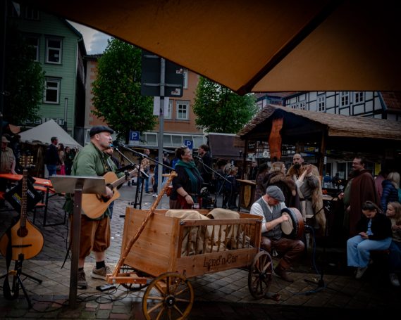Traditionelle Musikdarstellung auf einem Markt mit Künstlern und Zuschauern.
