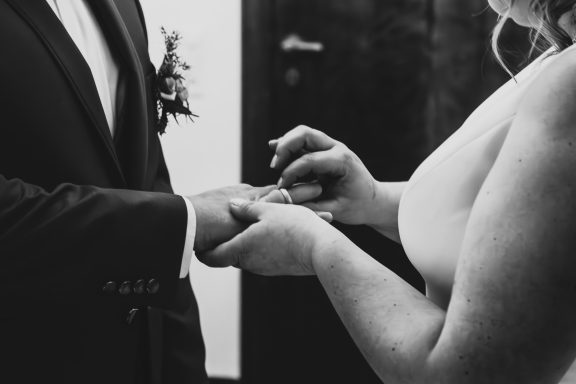 Hochzeitszeremonie: Eine Person zieht einer anderen einen Ring an.