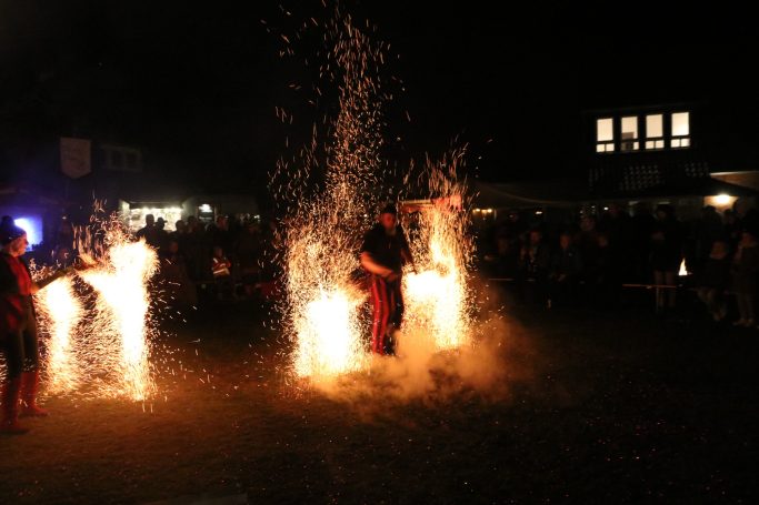 Feuerartistik mit Funken und Licht bei nächtlicher Veranstaltung im Freien.