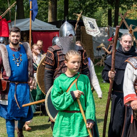 Mittelalterliche Gruppe mit Rüstungen und historischen Kostümen auf einem Festival.