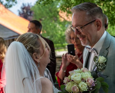 Braut und Bräutigam lächeln sich glücklich während der Hochzeitszeremonie an.