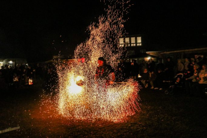 Feuerakrobat mit Funken und Flammen in einer nächtlichen Darbietung.