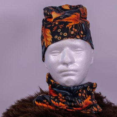 Modischer, gemusterter Schal und Mütze in orange-schwarzem Design auf einer weißen Büste.